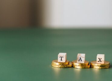 tax word on top of gold coins