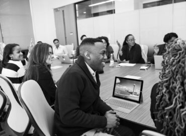group of people sitting in conference table laughing