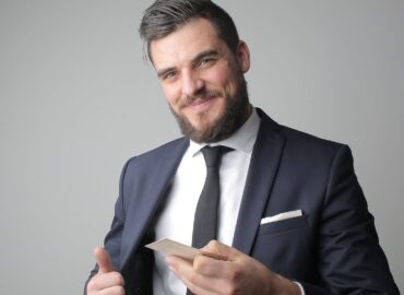 man in black suit holding a calling card