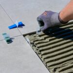 a close up shot of a person putting tile levelers