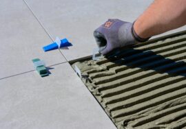 a close up shot of a person putting tile levelers