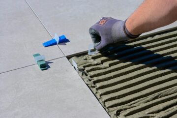 a close up shot of a person putting tile levelers