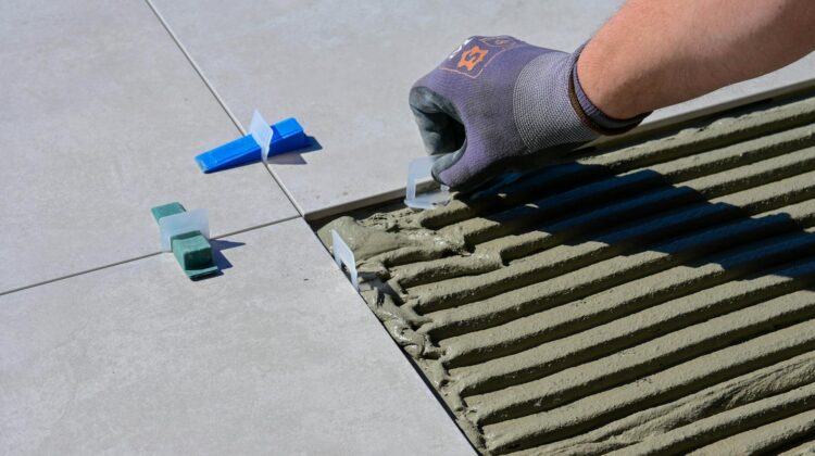 a close up shot of a person putting tile levelers