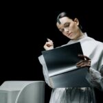 woman holding a pen while looking at a folder