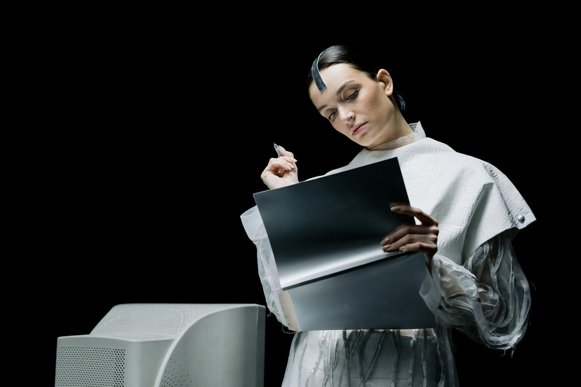 woman holding a pen while looking at a folder